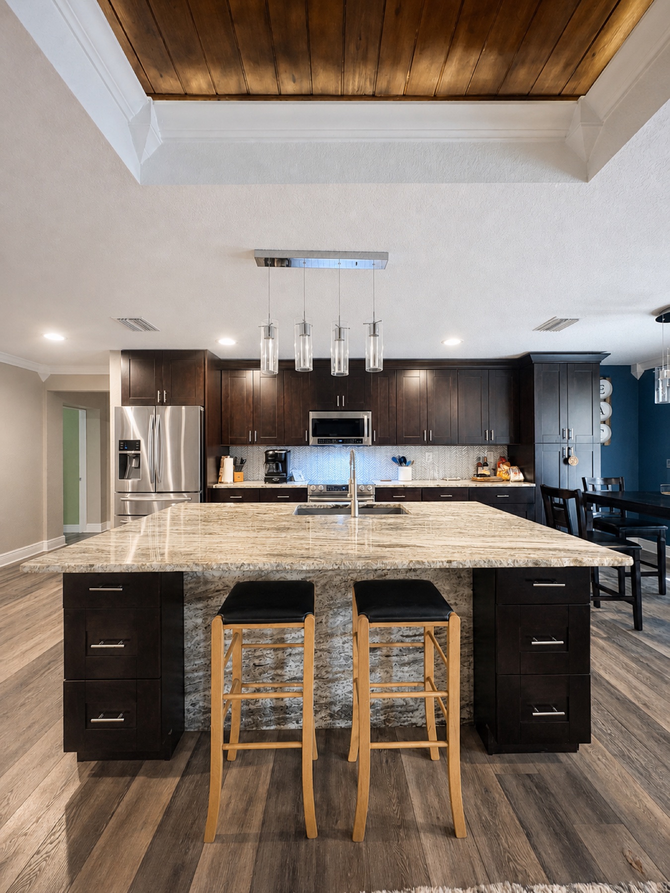 Polished kitchen with dark cabinetry and a large stone island